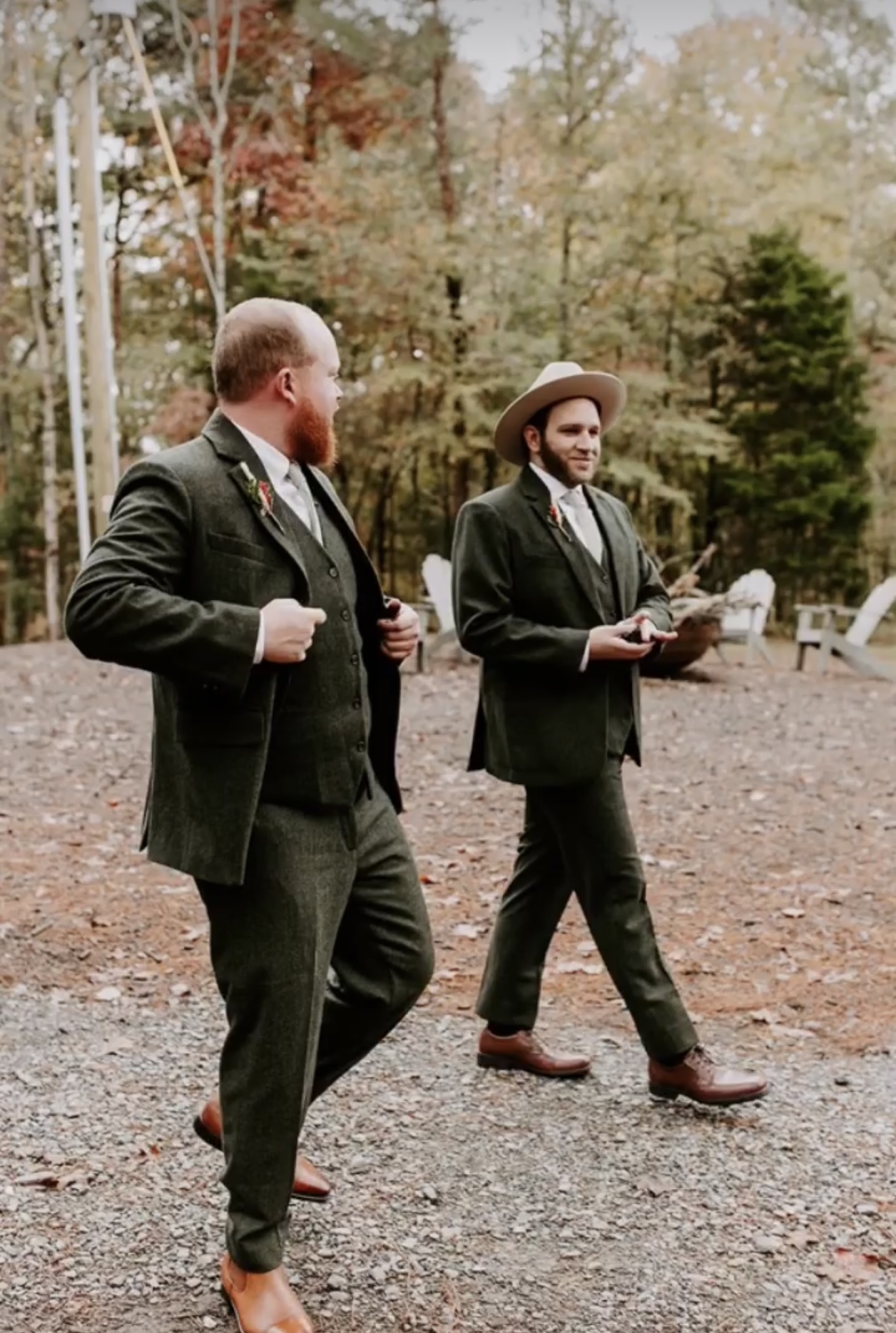 Groom and groomsman in forest green tweed suits at an outdoor wedding